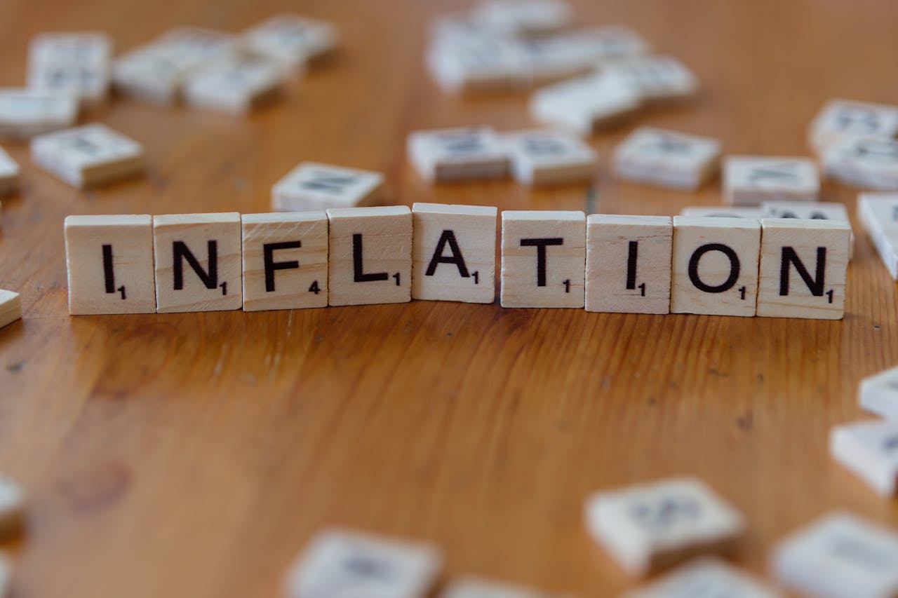 Scrabble letter tiles spelling INFLATION on a wooden table, signifying economic concepts.